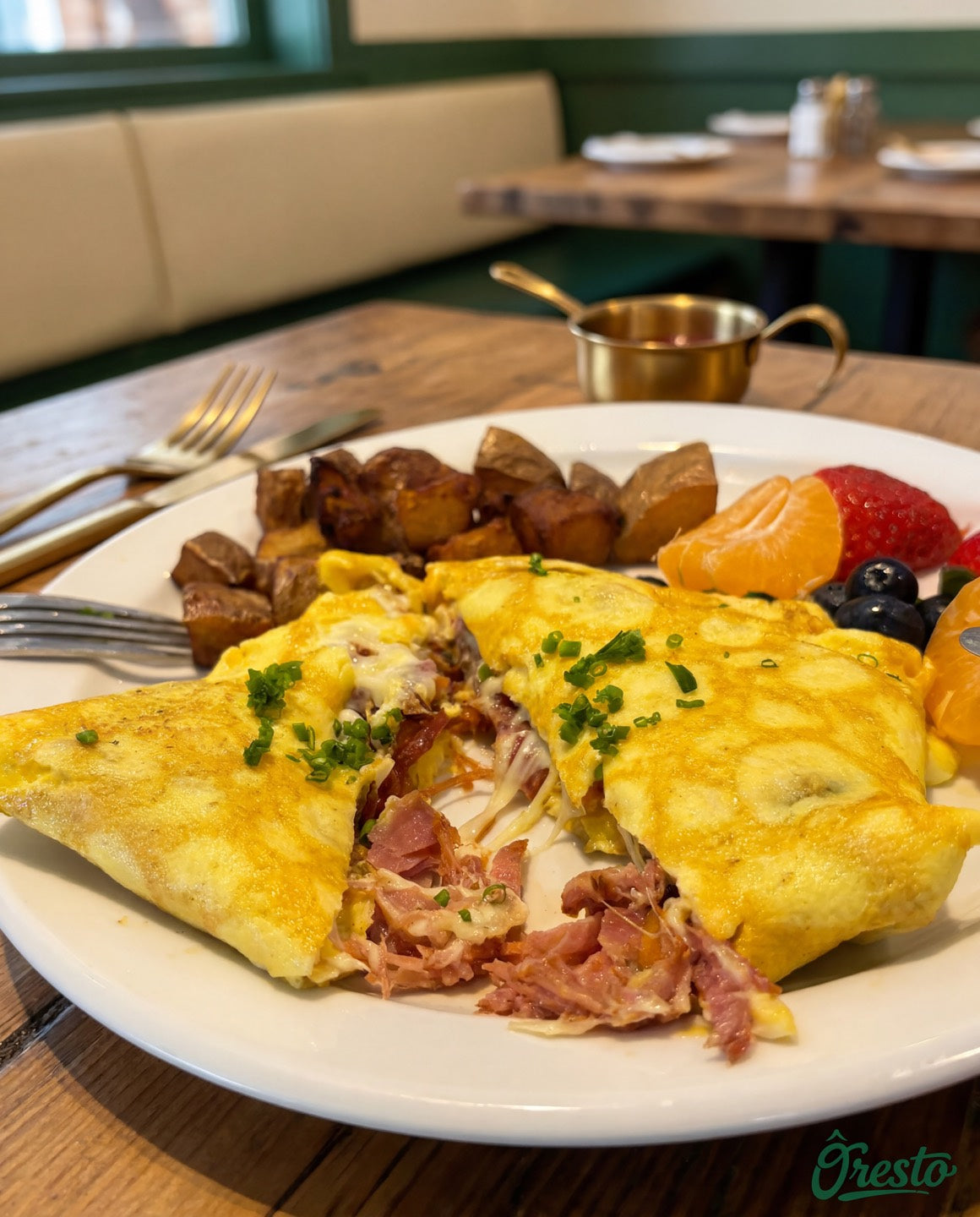 Omelette garnie avec fruits, pommes de terre et banquette verte